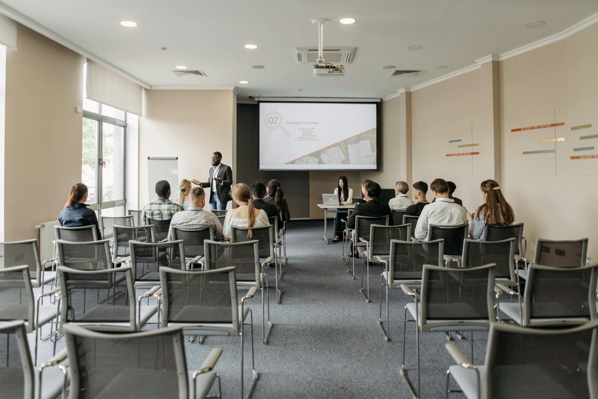 A group attending a business presentation in a modern conference room with projector.